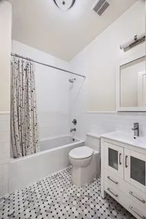 a bathroom with a sink toilet a mirror and shower