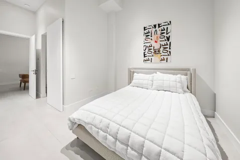 a bedroom with a bed and a night stand