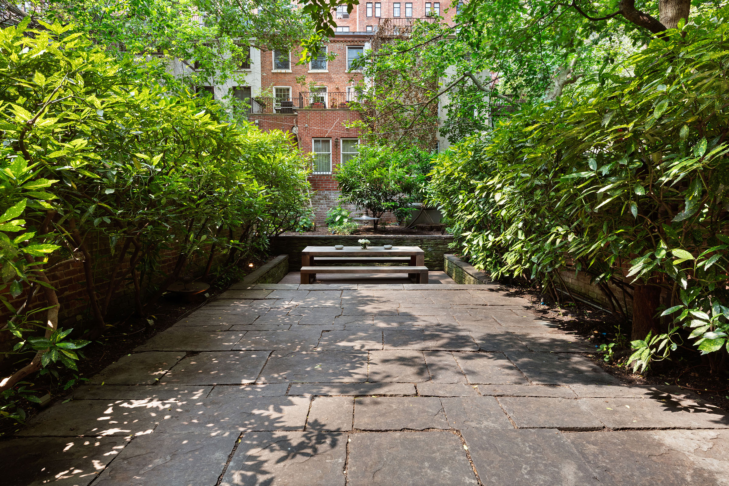 456 West 25th Street Manhattan, NY 10001 - Photo 14 of 22 a car parked in front of a brick house with large trees