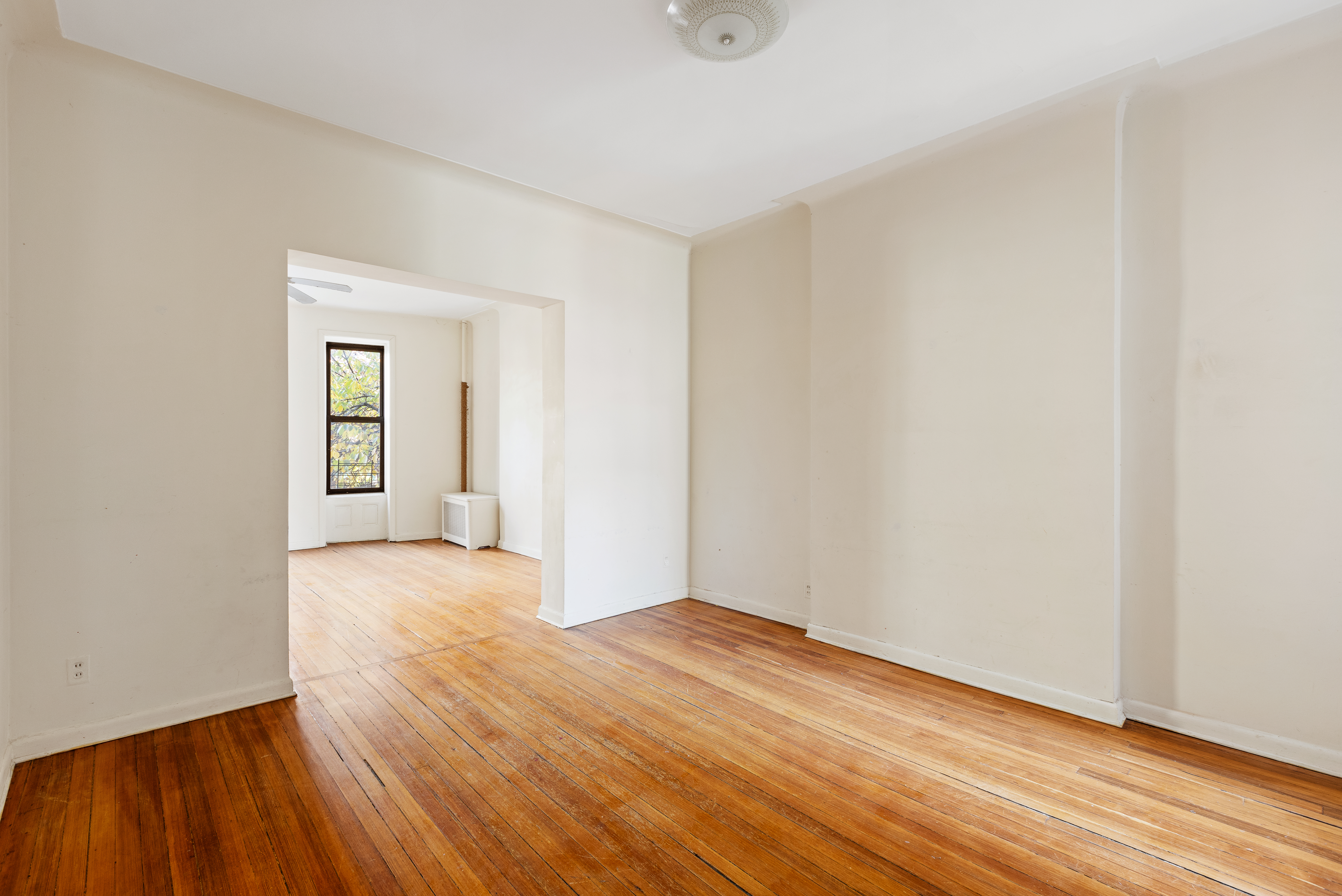 474 3rd Street, Unit 2L Brooklyn, NY 11215 - Photo 5 of 11 an empty room with wooden floor and a ceiling fan
