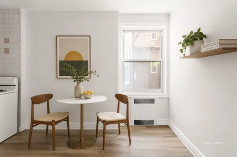 a view of a workspace room with wooden floor table and chairs