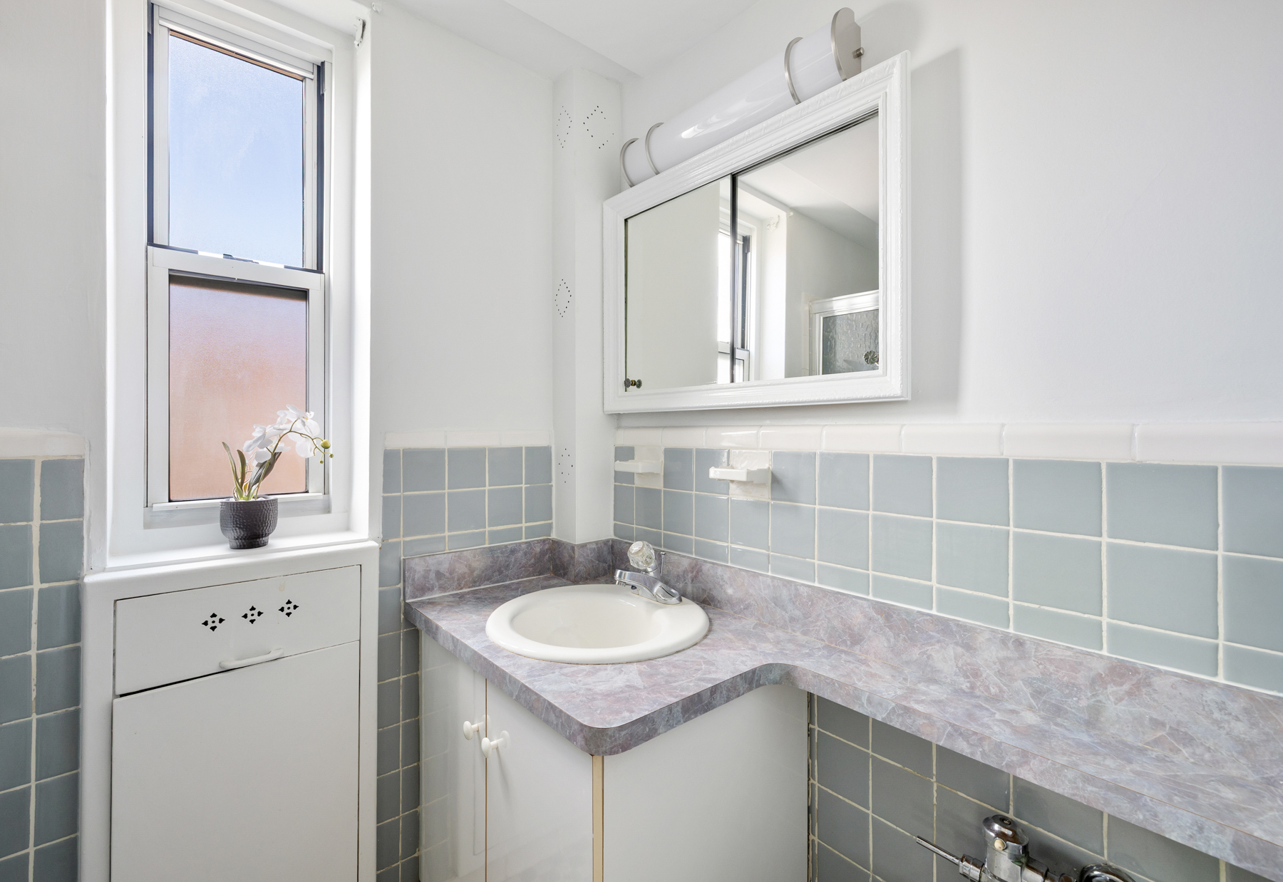 35-50 85th Street, Unit 9E Queens, NY 11372 - Photo 11 of 13 a bathroom with a sink and a mirror