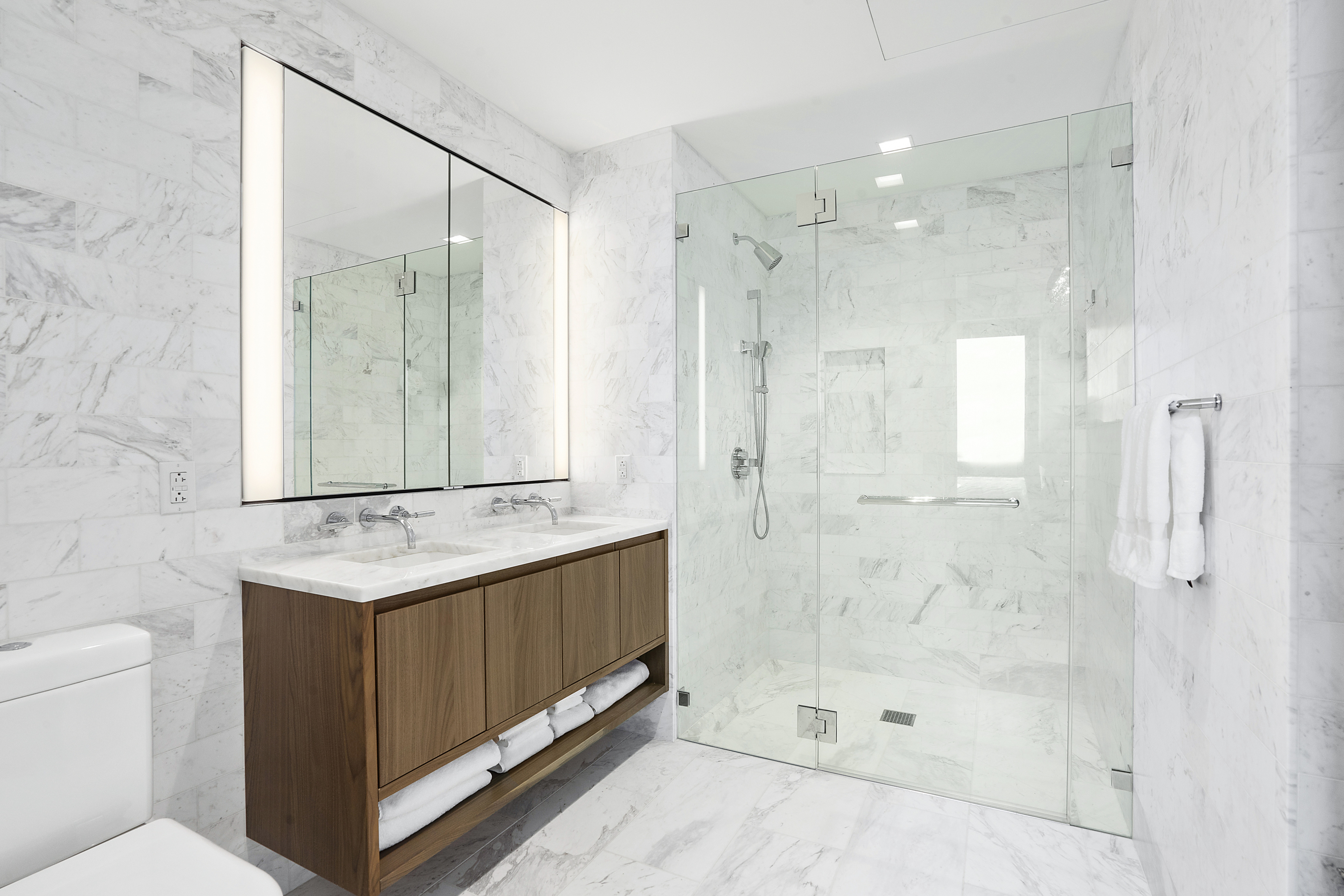 242 Broome Street, Unit 14A Manhattan, NY 10002 - Photo 5 of 6 a bathroom with a granite countertop sink mirror and shower