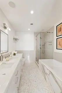 a spacious bathroom with a double vanity sink mirror and shower