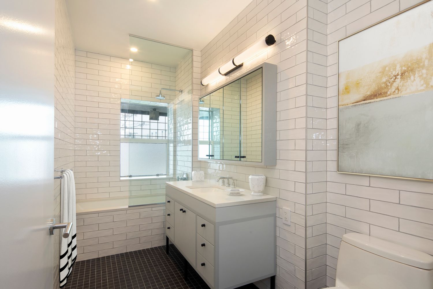 184 Kent Avenue, Unit C107 Brooklyn, NY 11249 - Photo 5 of 18 a bathroom with a sink a toilet a large mirror and shower