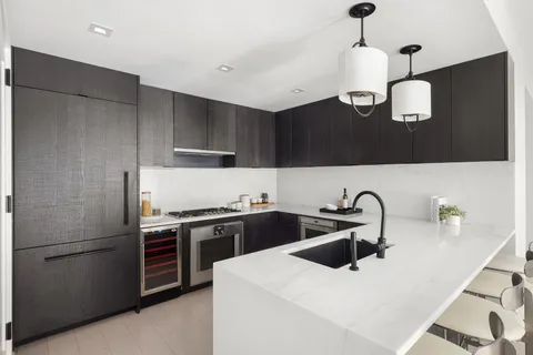 a kitchen with stainless steel appliances a sink a stove and refrigerator