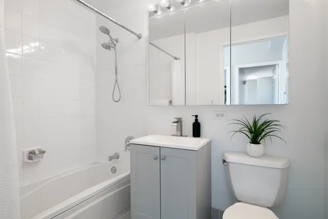 a bathroom with a sink a toilet a mirror and shower