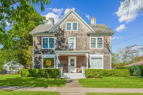 a car parked in front of house with large trees