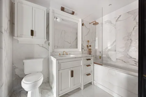 a bathroom with a granite countertop sink toilet a shower and a mirror