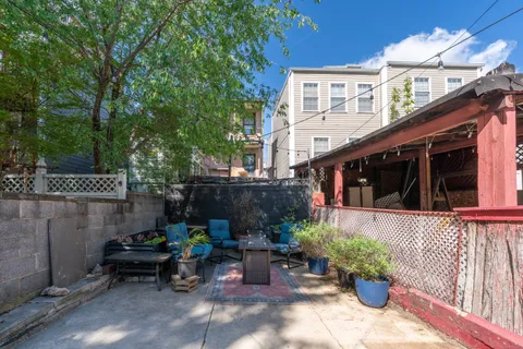 a view of a patio with table and chairs potted plants with wooden fence