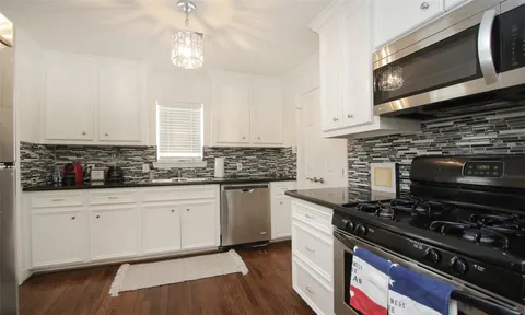 a kitchen with stainless steel appliances granite countertop a stove and a microwave