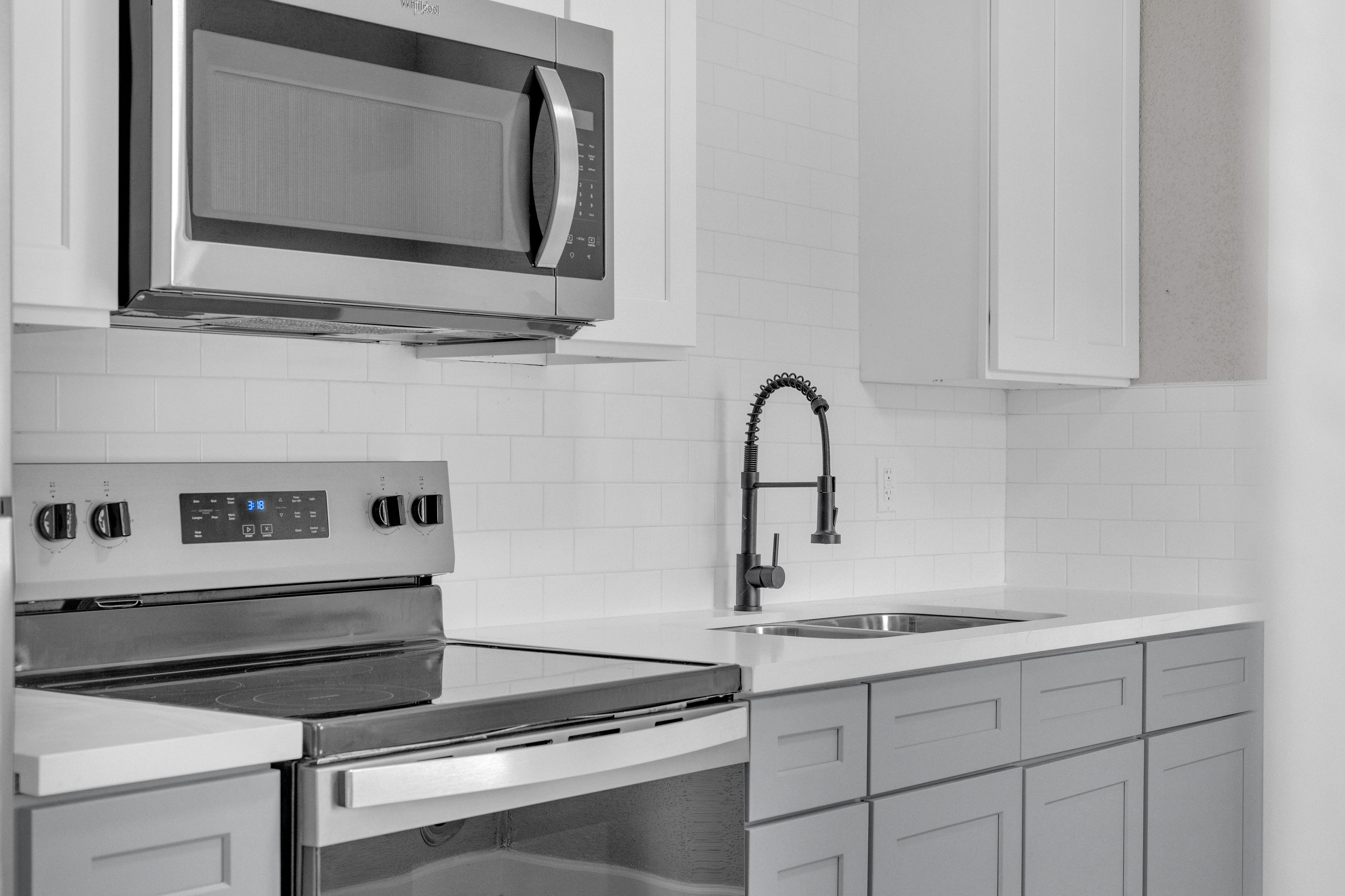 4755 Wilmington Street, Unit 6 Houston, TX 77033 - Photo 9 of 15 a kitchen with a stove microwave and sink