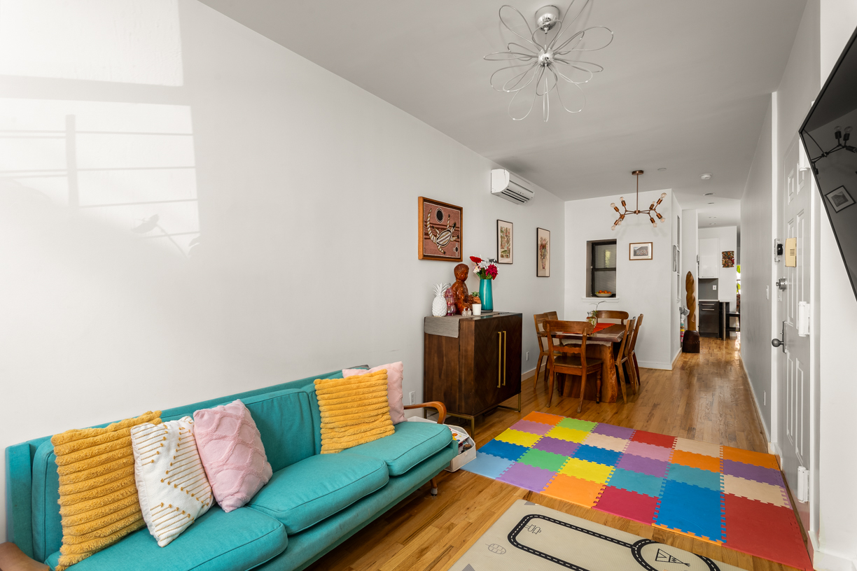 119 East 101st Street, Unit 1A Manhattan, NY 10029 - Photo 2 of 10 a living room with furniture and a dining table