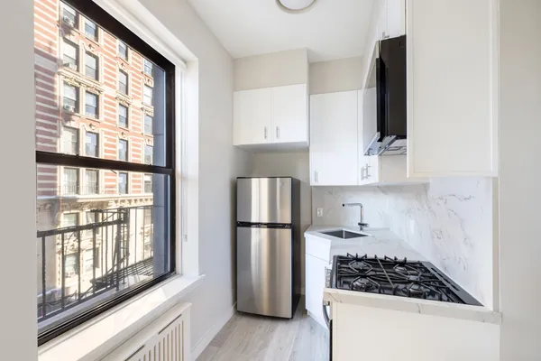 a kitchen with stainless steel appliances granite countertop a refrigerator and a stove top oven