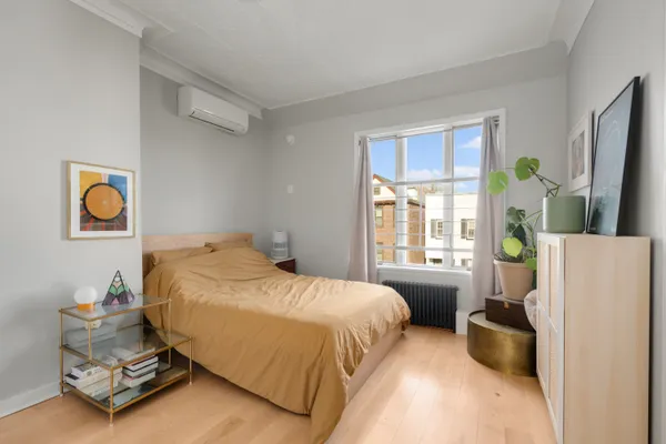 a bedroom with a bed and a potted plant