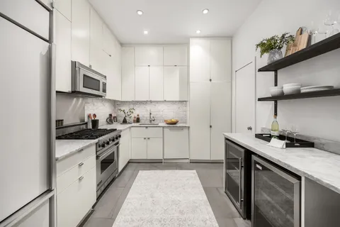 a kitchen with stainless steel appliances granite countertop a sink a stove a microwave and wooden cabinets