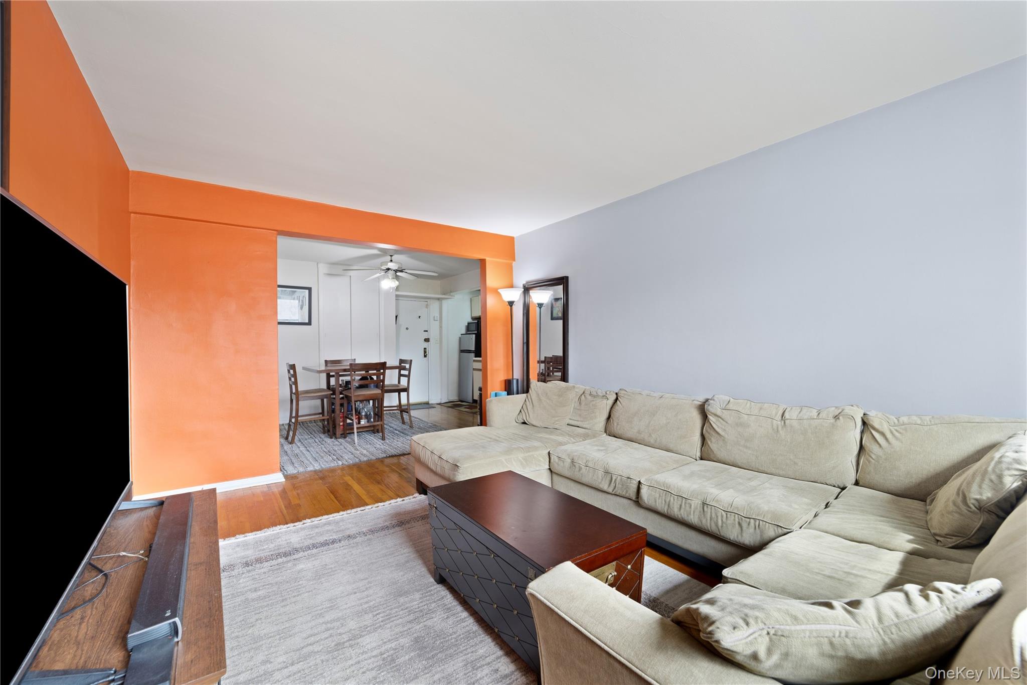 73-11 Bell Boulevard, Unit 2C Queens, NY 11364 - Photo 9 of 16 a living room with furniture and a flat screen tv