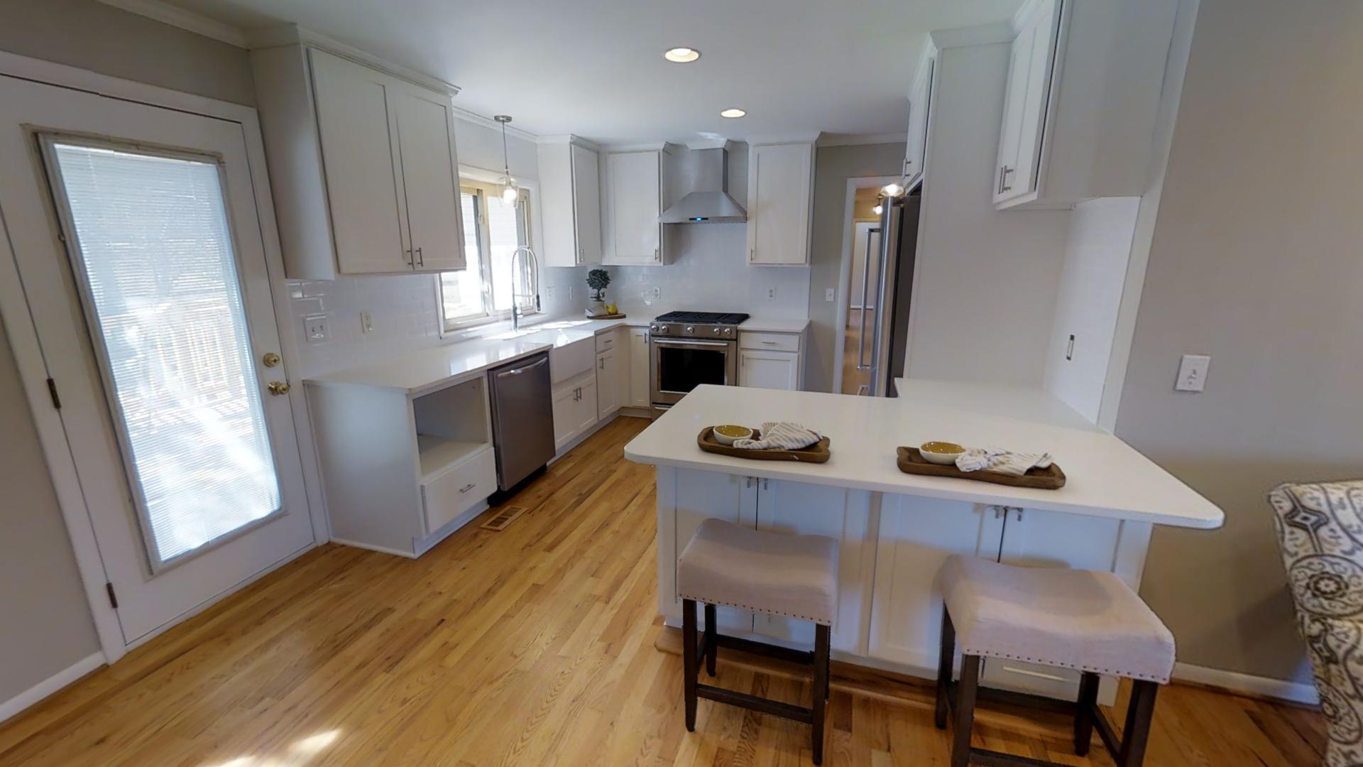 4425 Prescott Road Nashville, TN 37204 - Photo 8 of 26 a kitchen with a table chairs wooden floors and appliances