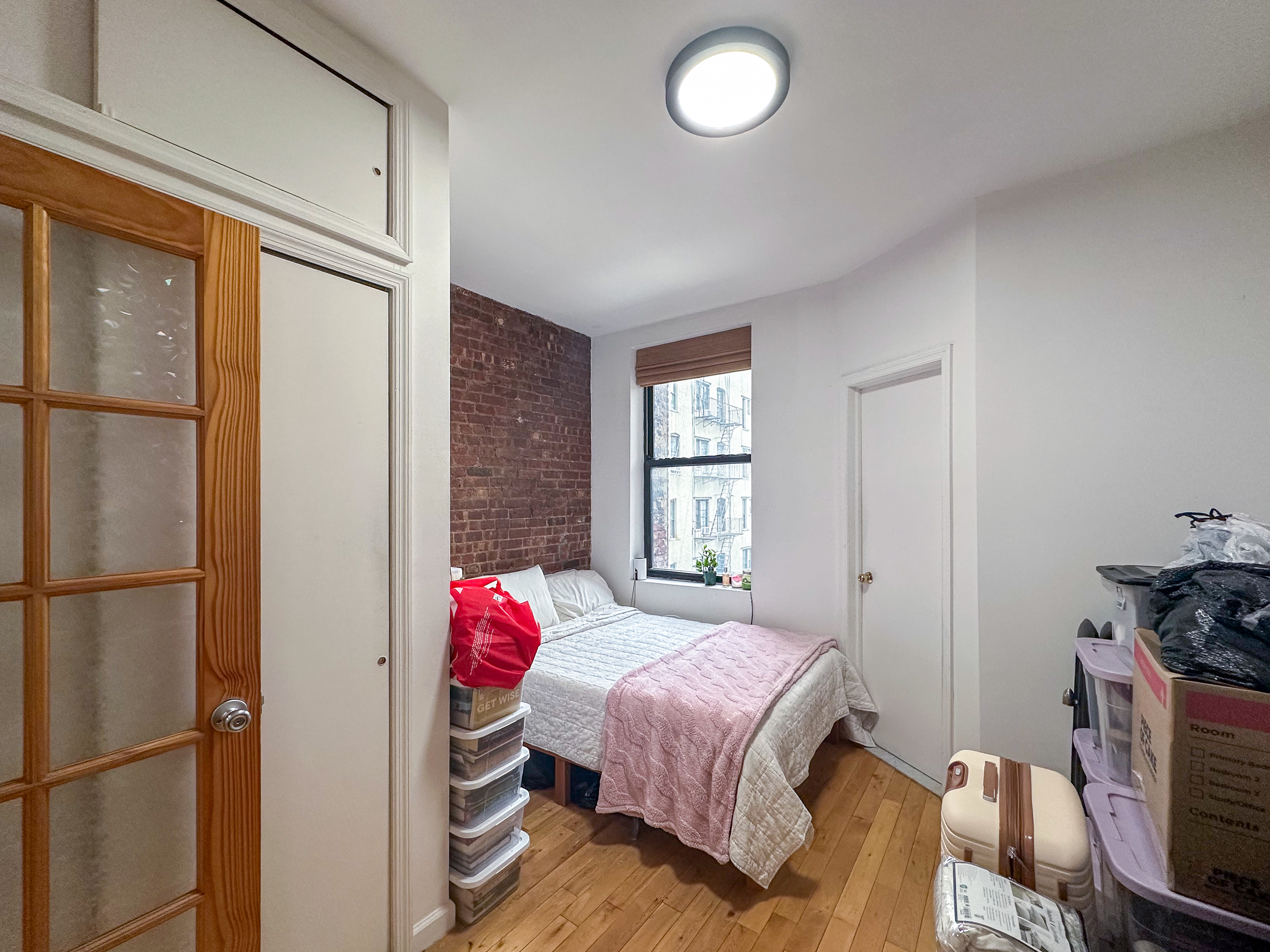 215 East 5th Street, Unit 7 Manhattan, NY 10003 - Photo 11 of 15 a bedroom with a bed and a window