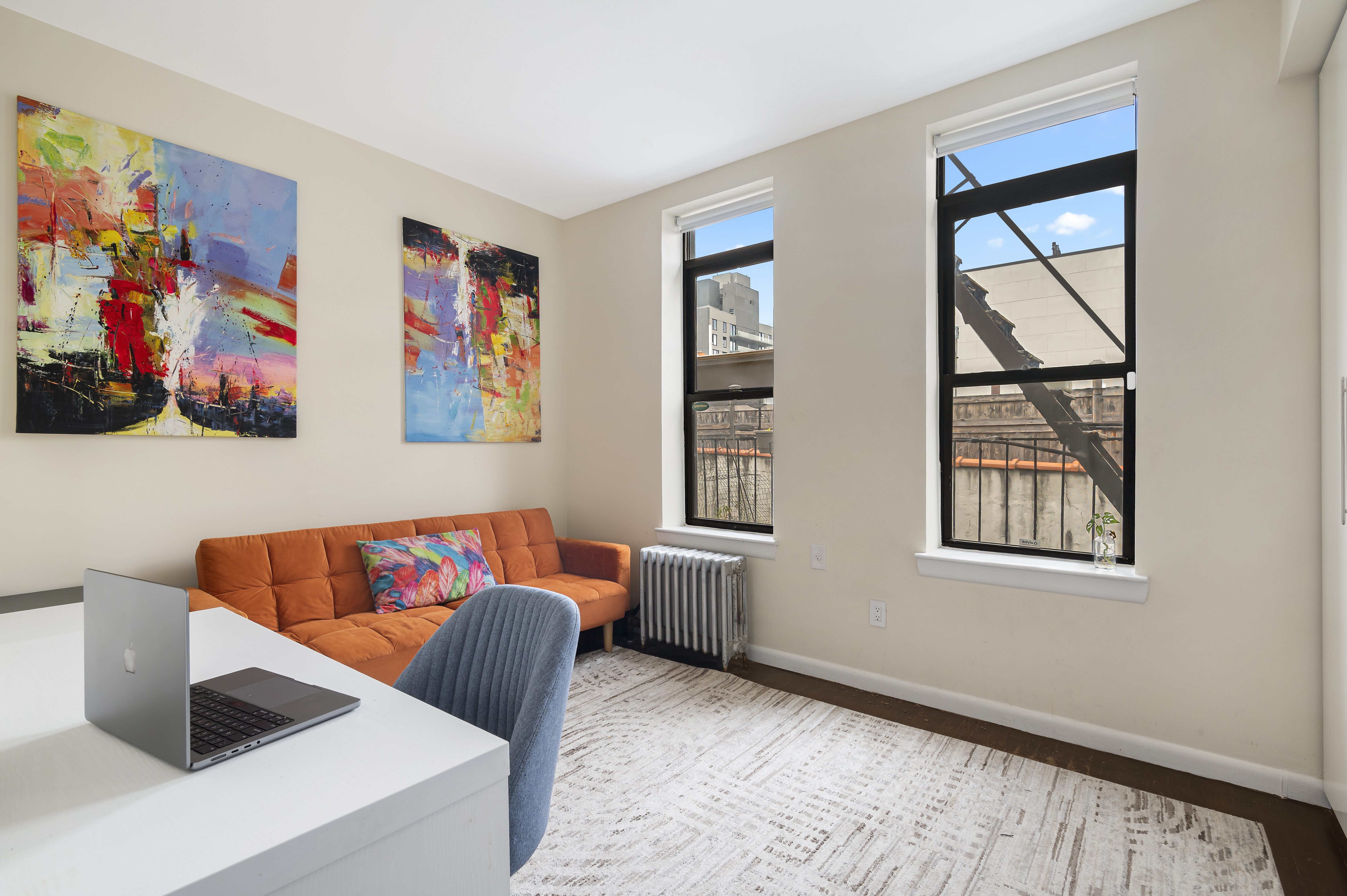 11 St Nicholas Avenue, Unit 5A/5H Manhattan, NY 10026 - Photo 3 of 6 a blue chair sitting in front of a window