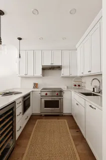 a kitchen with granite countertop white cabinets and white appliances