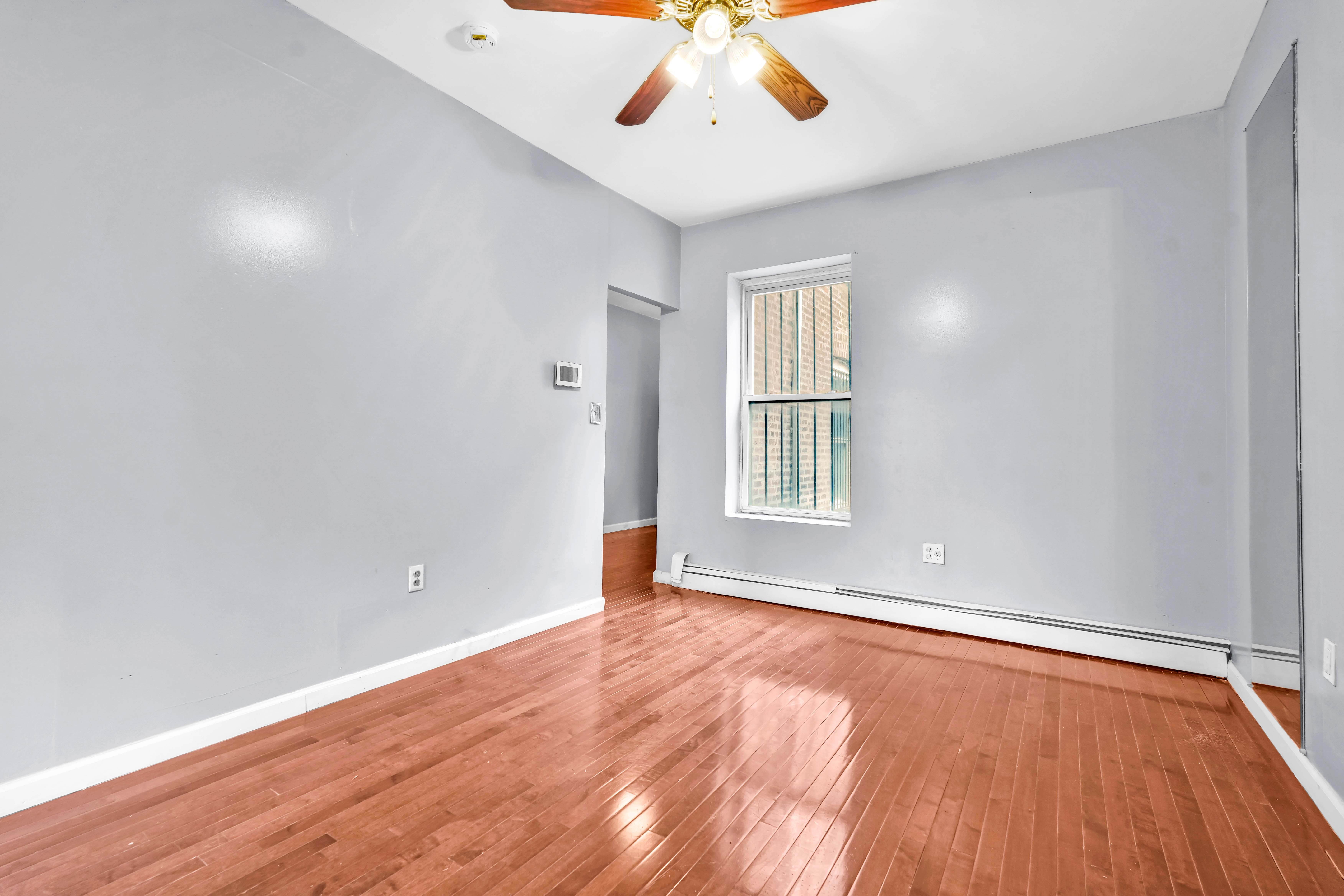 1633 St Johns Place, Unit 3 Brooklyn, NY 11233 - Photo 6 of 29 wooden floor in an empty room with a window