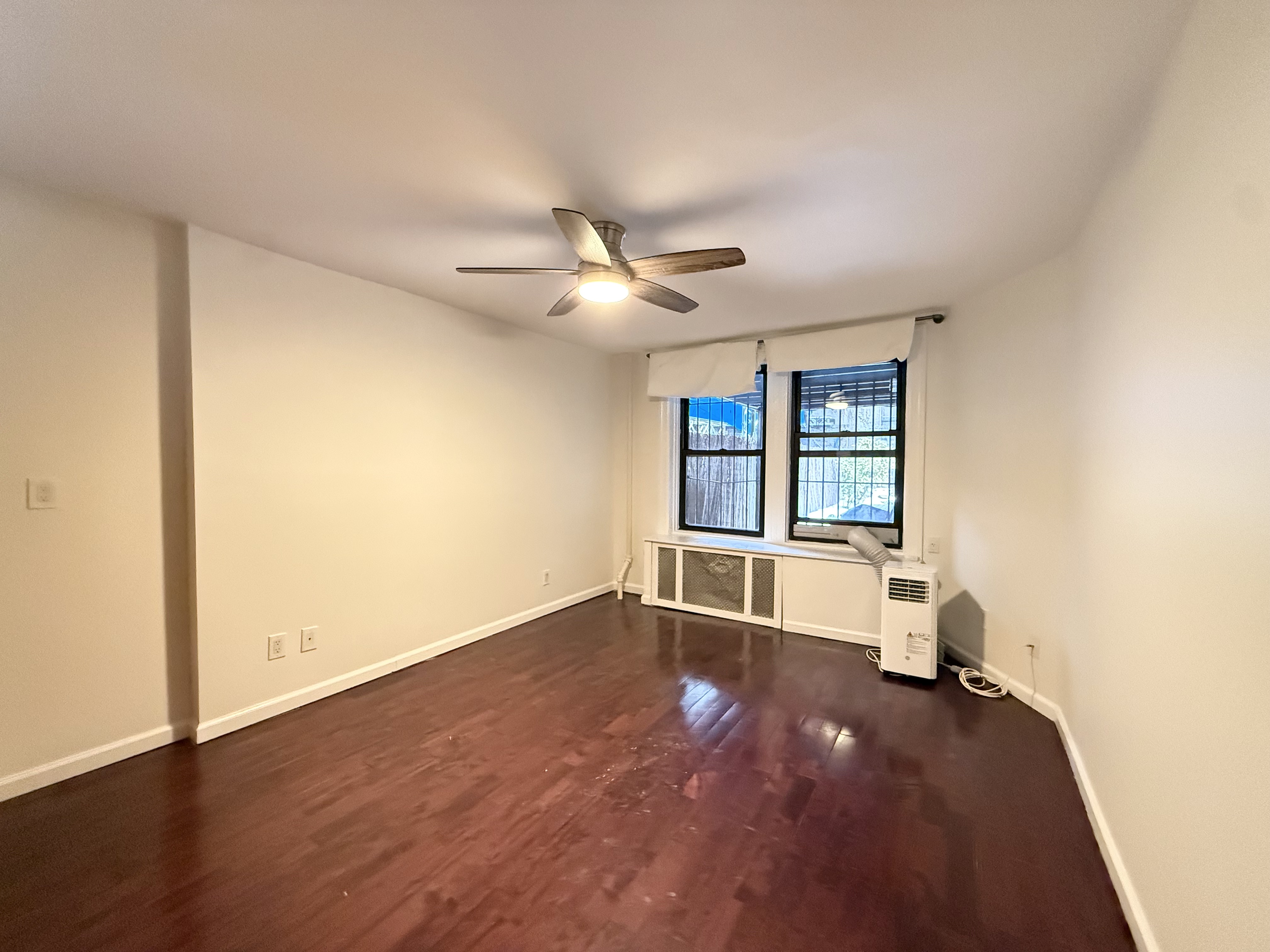 433 West 162nd Street, Unit 1 Manhattan, NY 10032 - Photo 7 of 13 an empty room with ceiling fan and windows