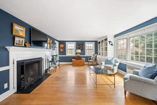 a living room with furniture large window and fireplace