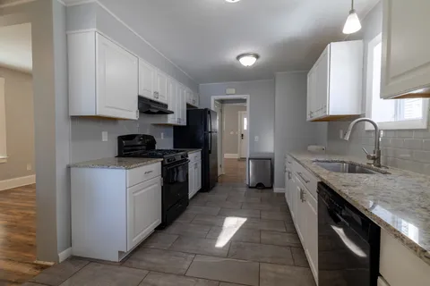 a kitchen with stainless steel appliances granite countertop a sink stove and cabinets