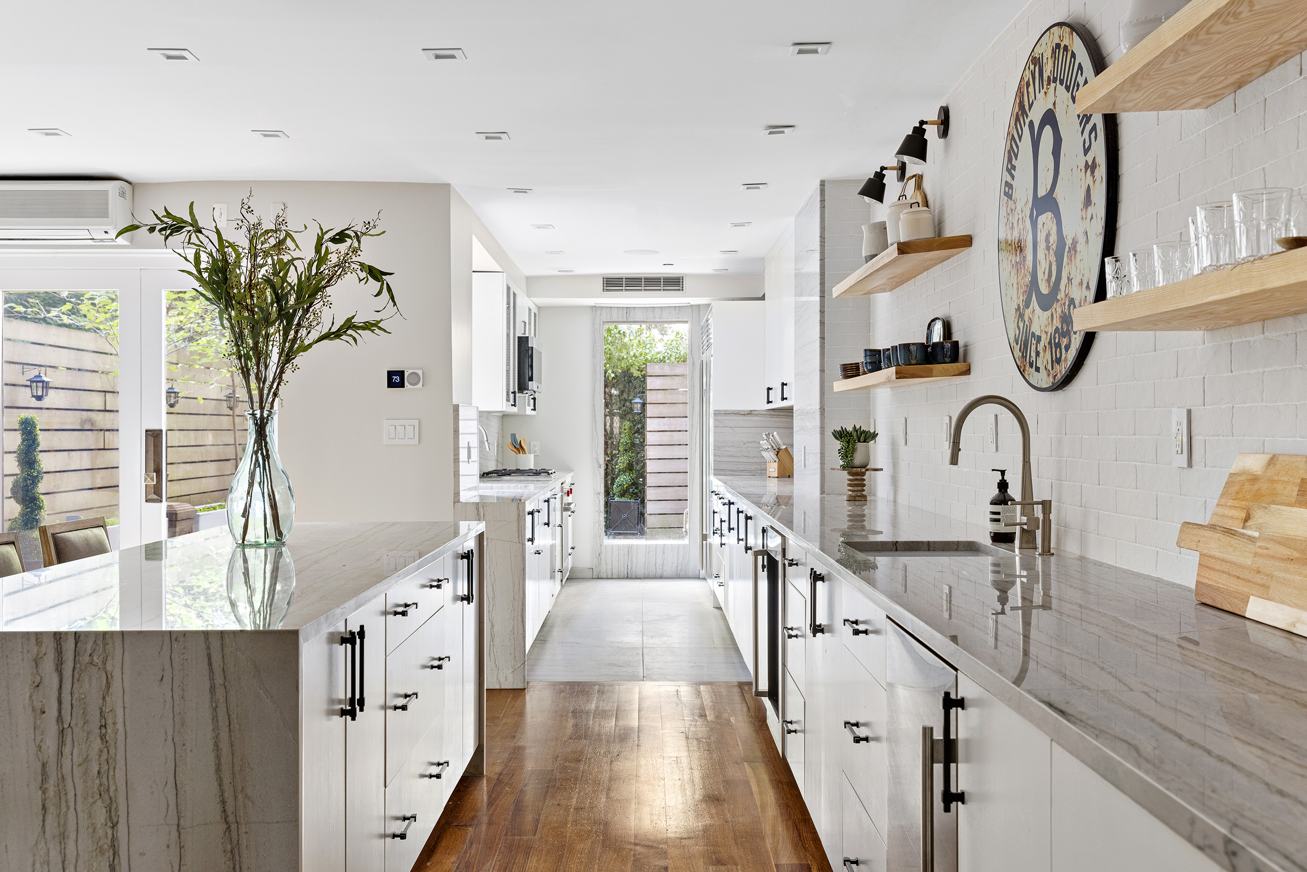 25 East 94th Street Manhattan, NY 10128 - Photo 3 of 33 a hallway with white cabinets and chandelier