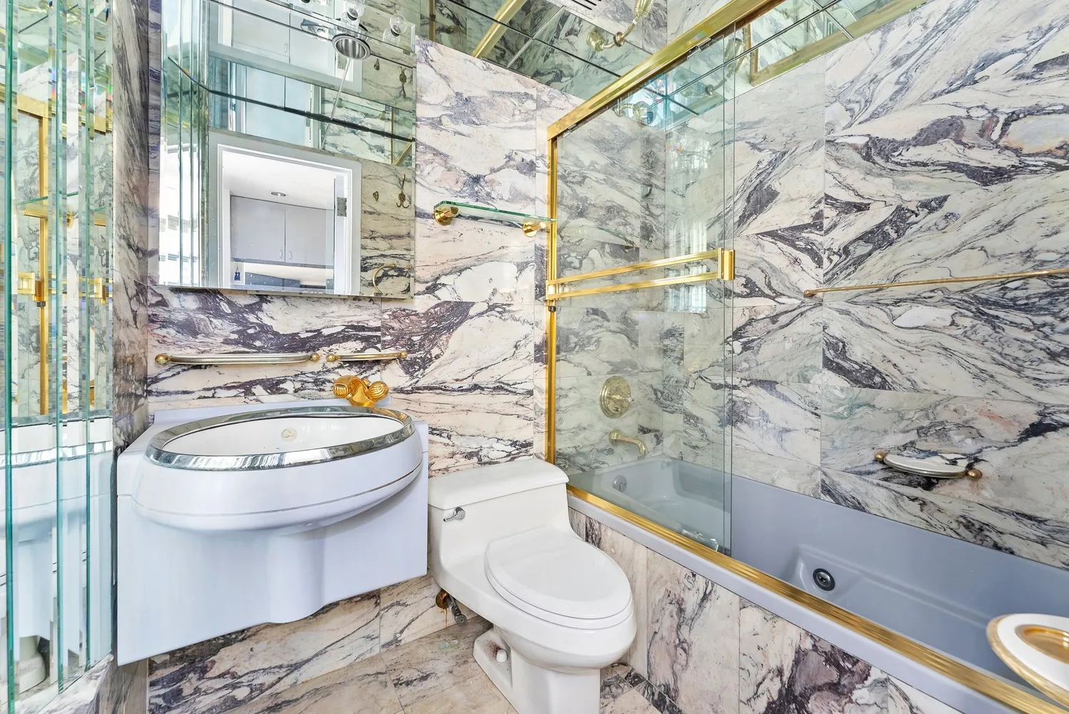 a white toilet sitting next to a bathroom sink and a mirror
