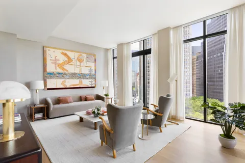 a living room with furniture and floor to ceiling windows