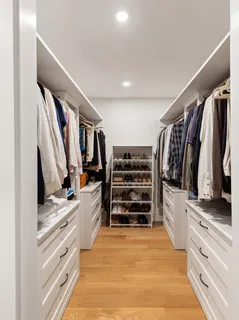 a view of walk in closet with clothes and shoes
