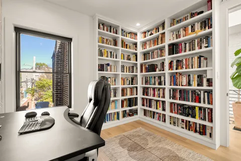 a view of a livingroom with furniture and a book shelf