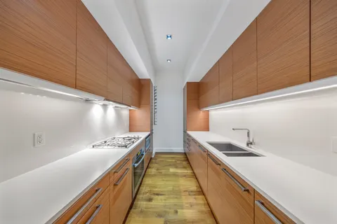 a kitchen with stainless steel appliances sink stove and cabinets