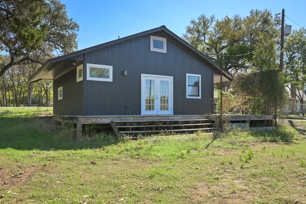 a backyard of a house with a yard table and chairs