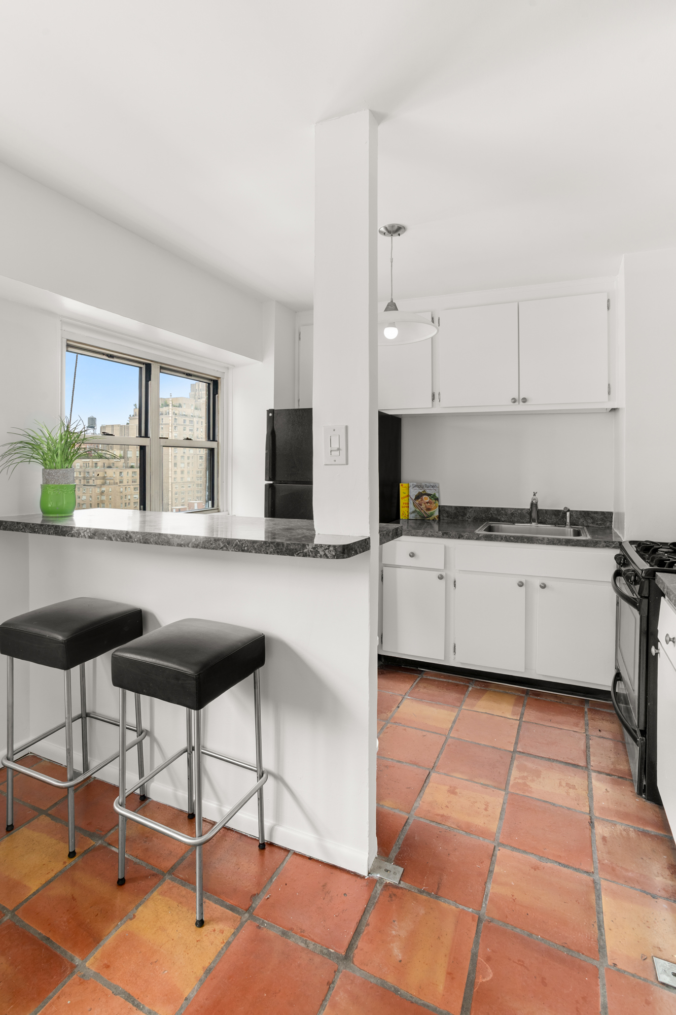 609 Columbus Avenue, Unit 14E Manhattan, NY 10024 - Photo 6 of 24 a kitchen with stainless steel appliances kitchen island granite countertop a stove a sink and a granite counter tops