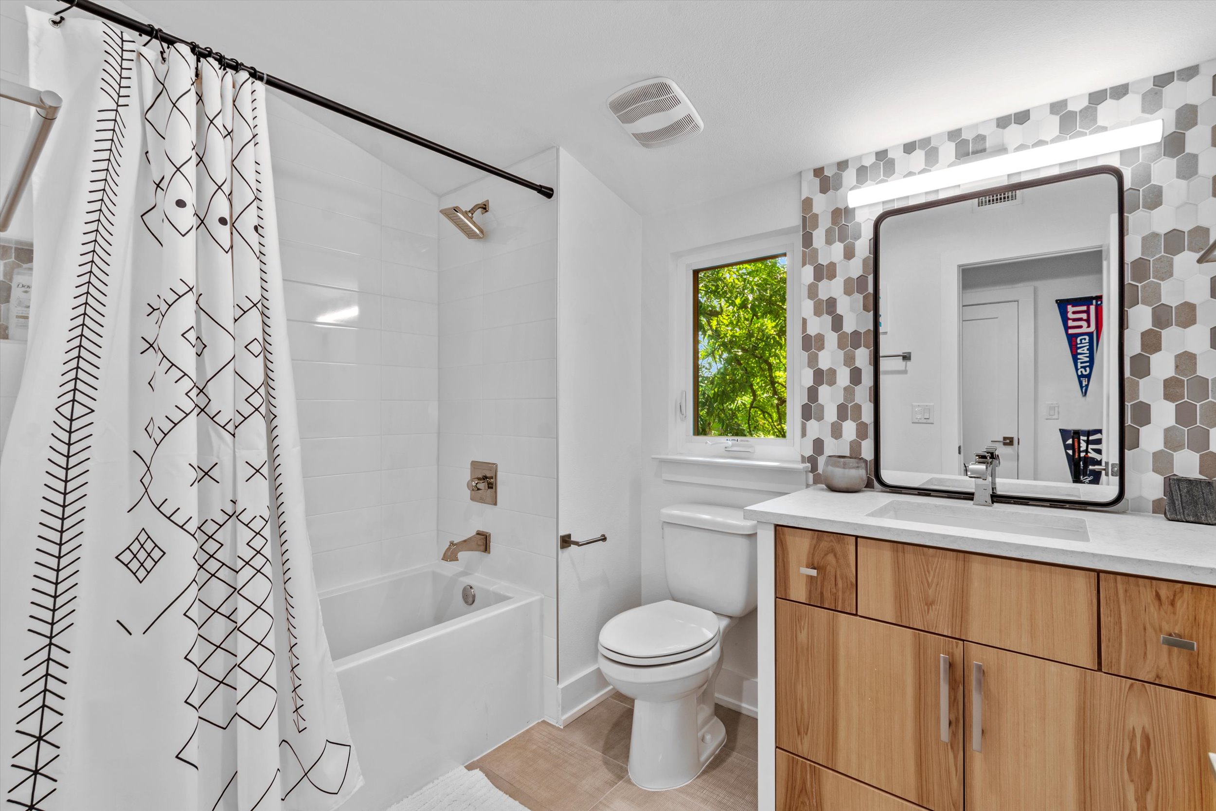 2712 Oak Springs Drive, Unit A Austin, TX 78702 - Photo 16 of 38 a bathroom with a granite countertop sink toilet a mirror a bathtub and shower