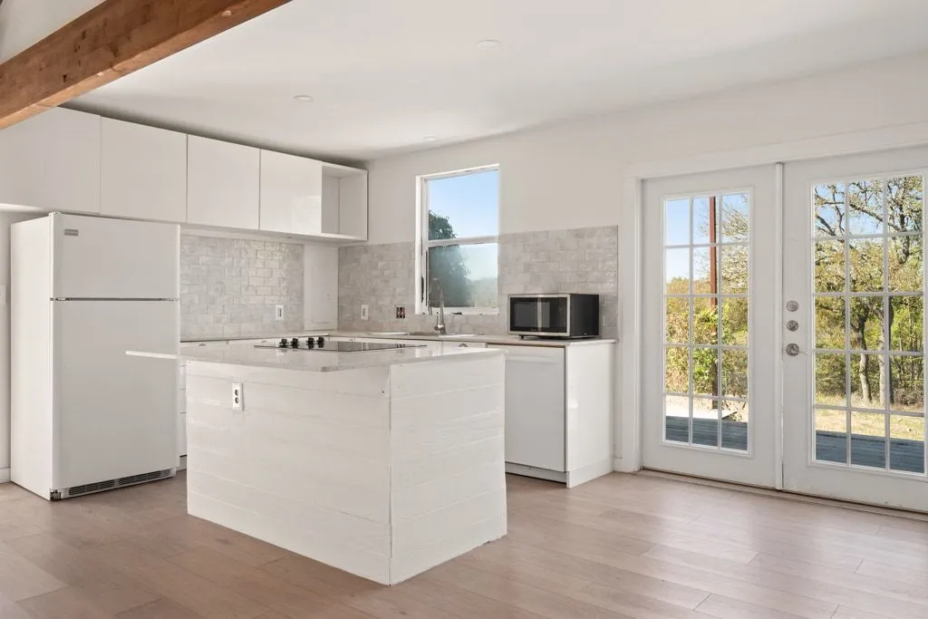 a kitchen with kitchen island white cabinets and refrigerator