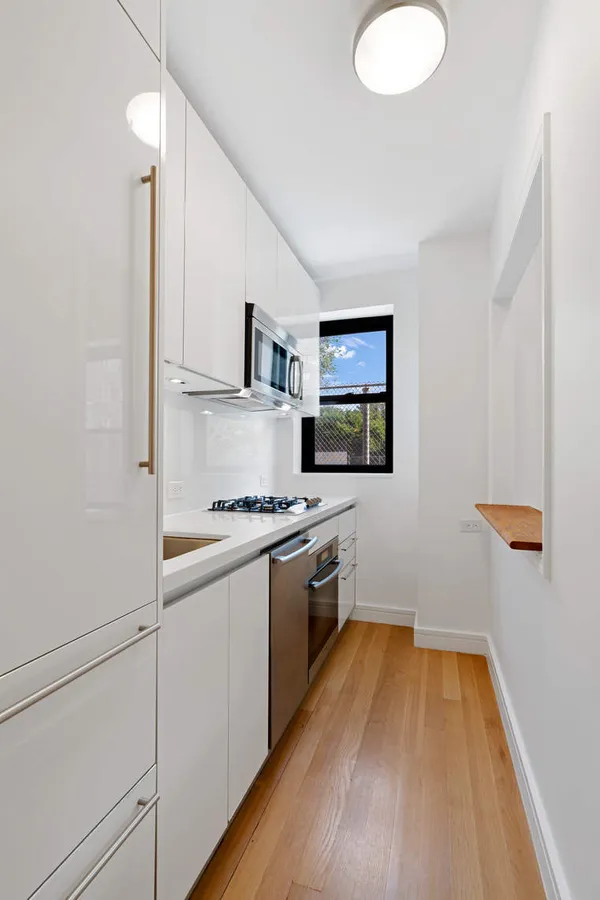 a kitchen with wooden floor and stainless steel appliances