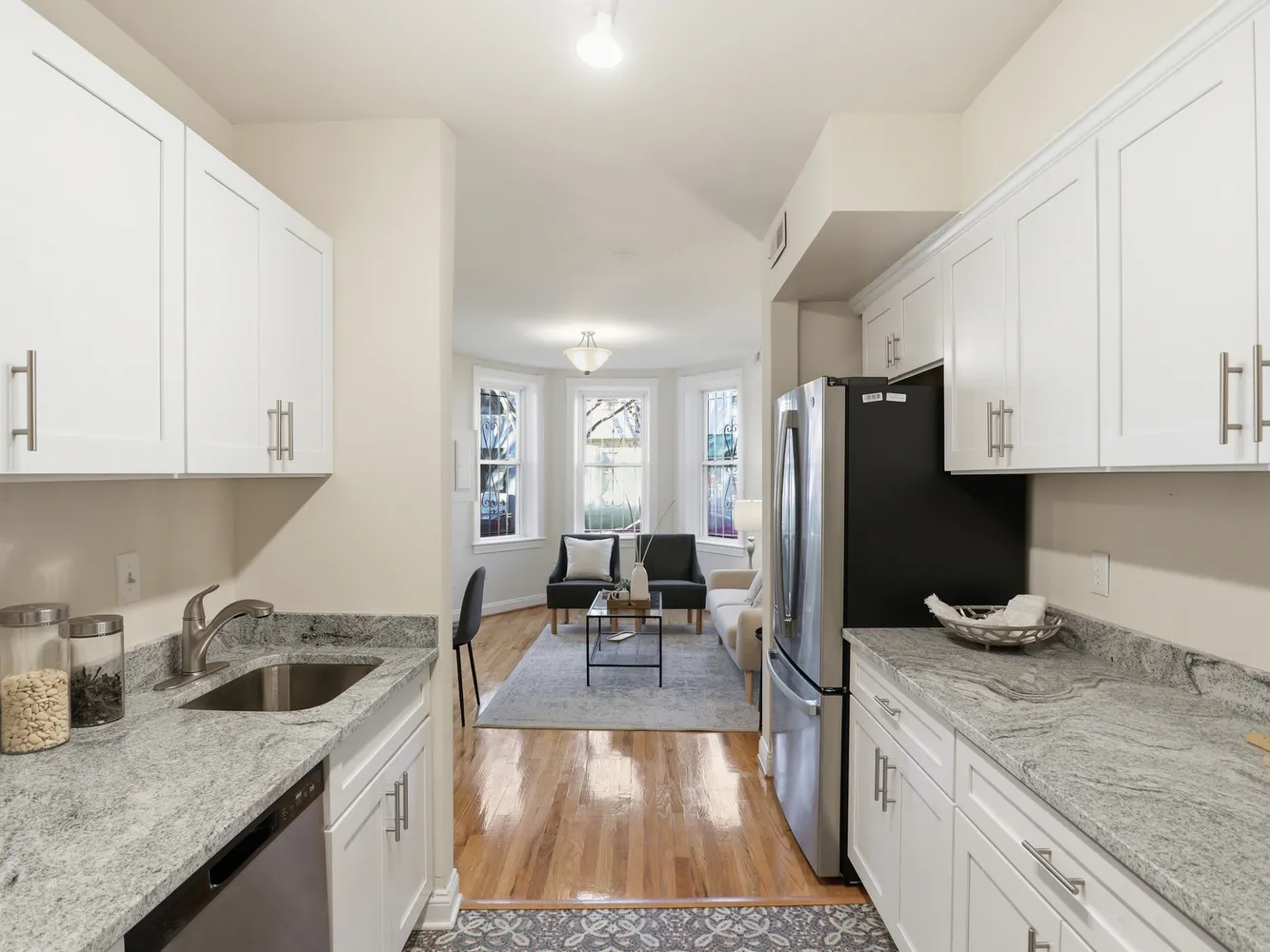 a kitchen with granite countertop a sink stove and refrigerator