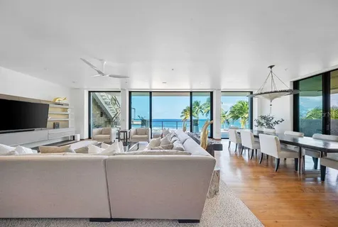 a living room with furniture wooden floor and a large window