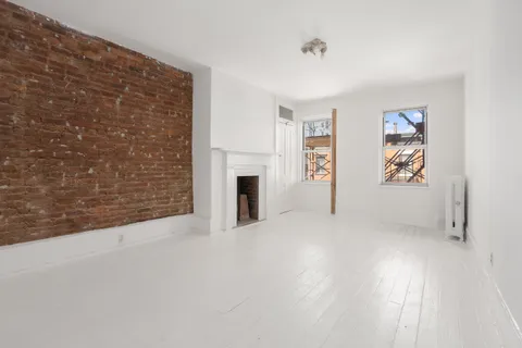 a view of an empty room with a fireplace and a window