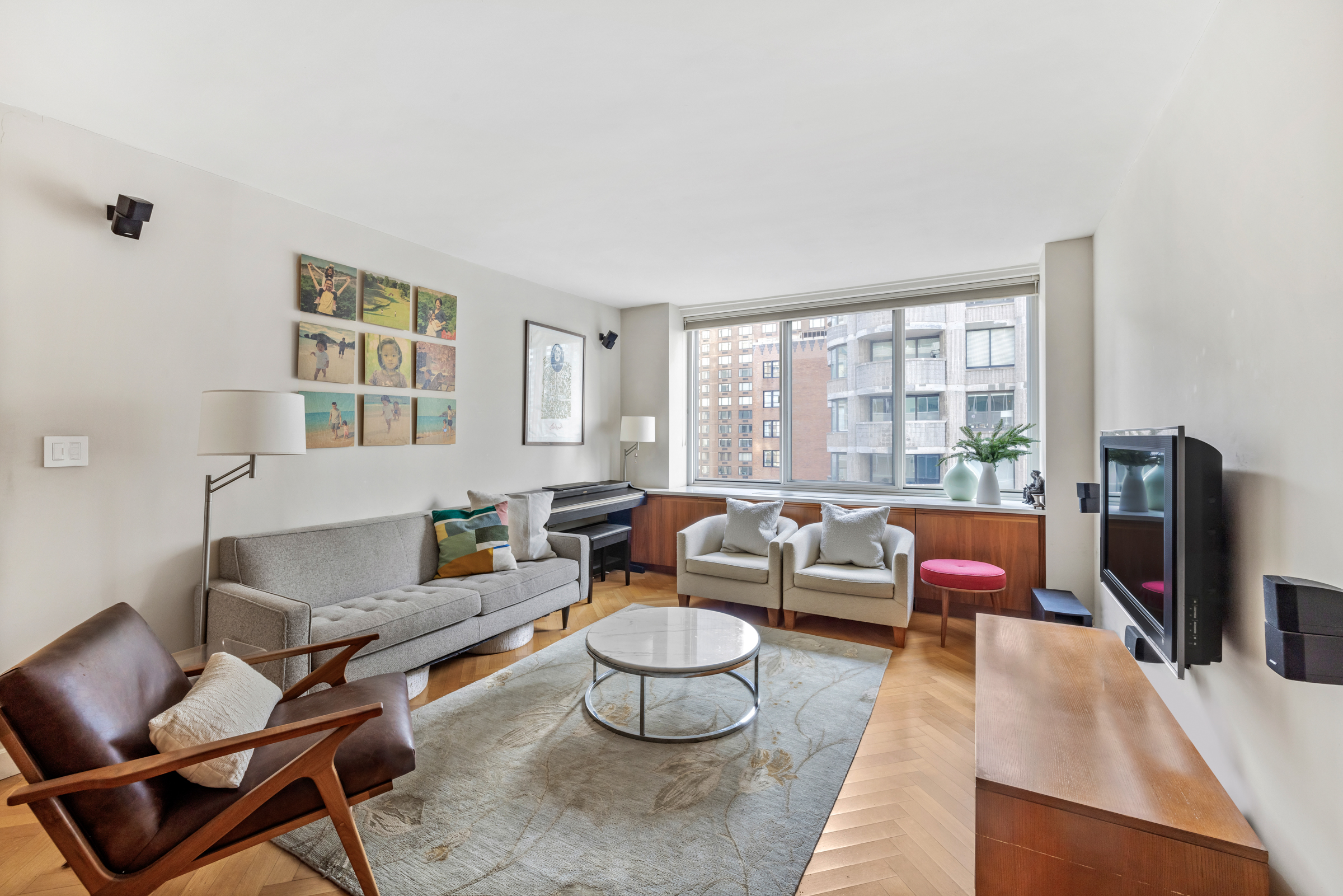 61 West 62nd Street, Unit 23G Manhattan, NY 10023 - Photo 2 of 9 a living room with furniture and a flat screen tv