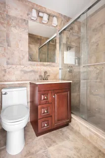 a bathroom with a toilet a sink and mirror