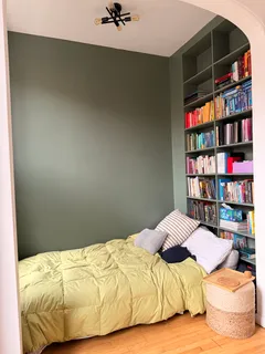 a bedroom with a bed and a book shelf