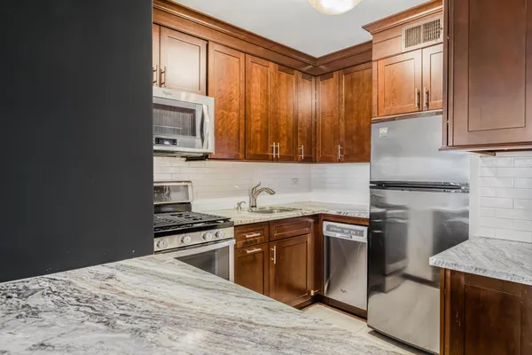 a kitchen with stainless steel appliances granite countertop a stove a sink and a microwave