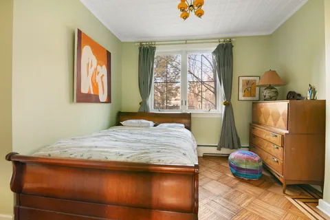 a bedroom with a bed and wooden floor