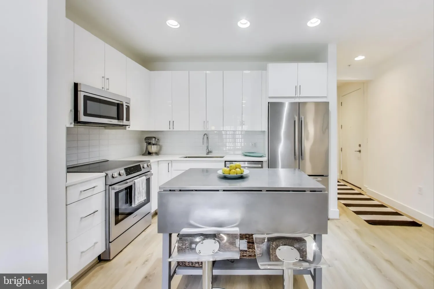 a kitchen with stainless steel appliances a stove a sink and a refrigerator