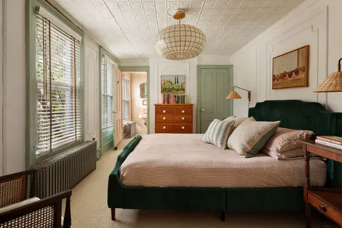 a bedroom with a bed mirror and window